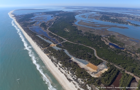 An aerial view of parking lots in progress along the ocean.