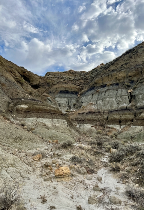 A badland formation under a cloudy sky.