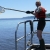 Woman on boat with fish net in hand on Mississippi river.