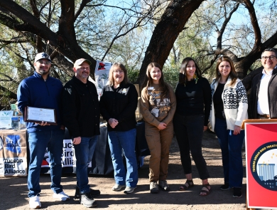 seven people stand together smiling in front of a podium that says Tucson urban bird treaty coaltion