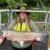 Haley on a boat holding a 3 foot long grass carp