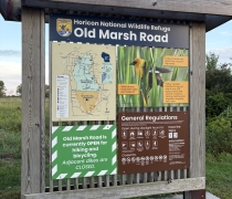 Wooden one panel kiosk with signage that says Old Marsh Rd, map and regulations