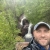 Person standing with a waterfall over their shoulder.
