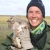 Woman in warm clothing holding baby goose