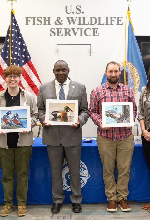 six people standing with artwork