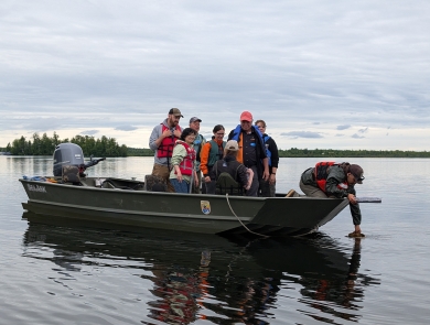 Biologist on boat sample for aquatic invasive species.