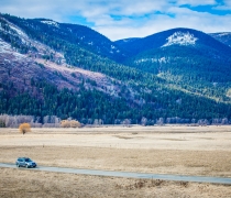 A car drives along riverside road at Kootenai NWR