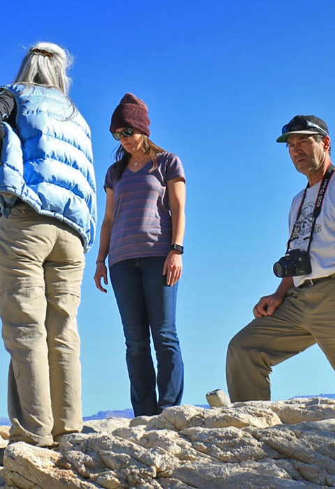 Four adults stand on rock overlooking valley