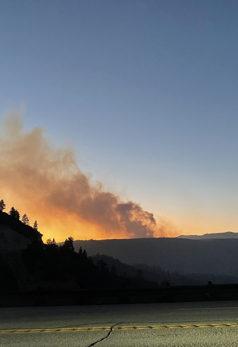 a smoke plume emerges from a mountain at sunrise