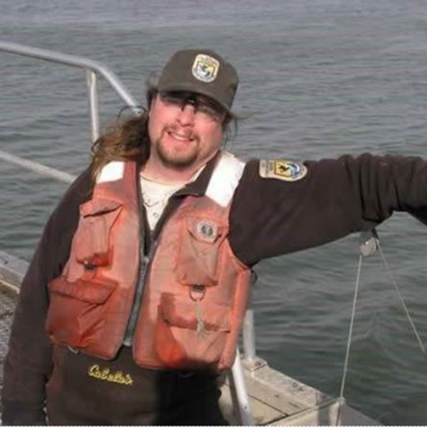 Dr. Robert Allan Klumb in his Service uniform leaning on the rail of a boat. Image from In Memory of Robert Allan Klumb Facebook page, www.facebook.com/RobertAllanKlumb/photos/a.527812897272927/527812903939593/.