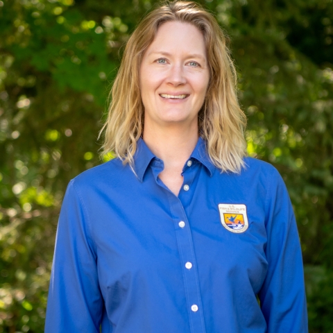 Female standing, wearing a blue shirt
