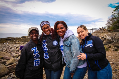 Four smiling women wearing Zeta Phi Beta sweatshirts pose for the camera.