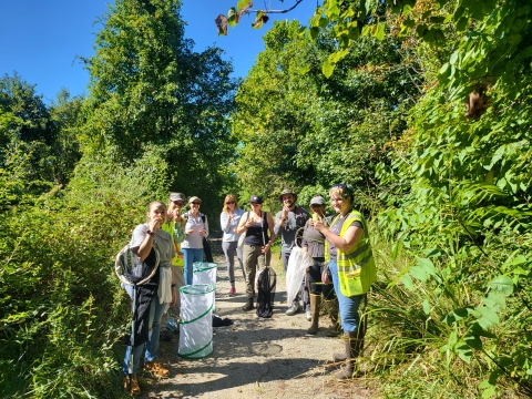 A group of people outside with butterfly nets and enclosures