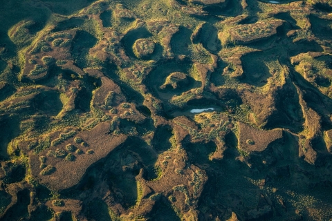Aerial photo of a landscape channeled by ancient floods into many smaller plateaus. 