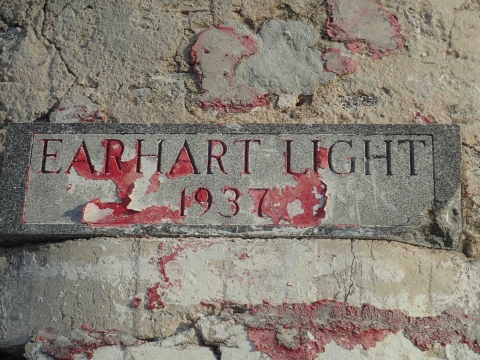 The worn, stone sign that says Earhart Light 1937 sit on top what remains of the lighthouse on Howland.