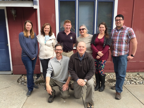 A group of 8 men and women pose for a group photo