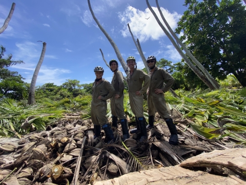 Four devoted team members celebrate after clearing a plot. 