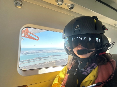 Texas Coastal Program Biologist, Adriana Leiva, in an airplane participating in the 2026 whopping crane winter survey