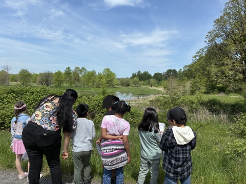 A group of school children look out across a pond at the Ridgefield National Wildlife Refuge