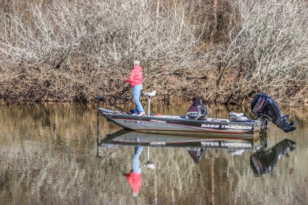 An image of a person fishing from a motorized boat.