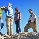 Four adults stand on rock overlooking valley