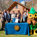 A group of people standing behind Nevada governor Steve Sisolak during a document signing event