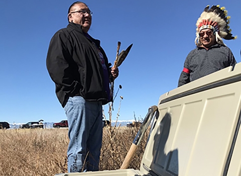 Oglala Lakota and Southern Ute Tribe leader stand over a container of eagle remains.