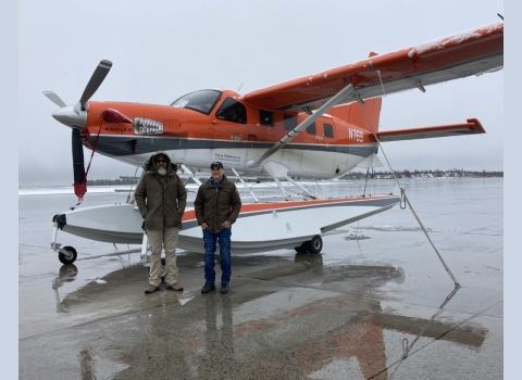 2 people standing in front of an airplane